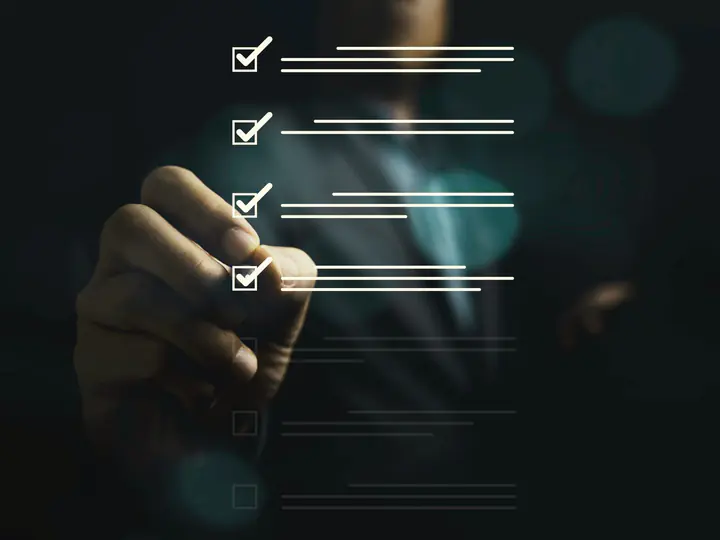 A hand ticking off items on a checklist